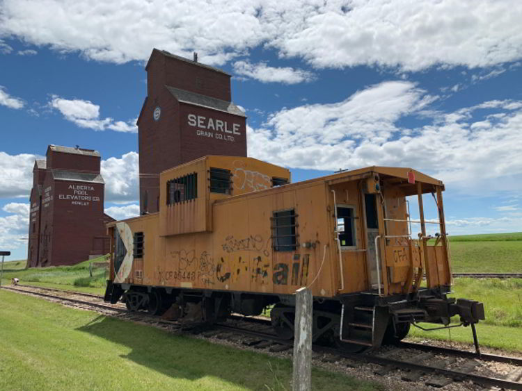 An image of the caboose and grain elevator in Rowley, Alberta. 
