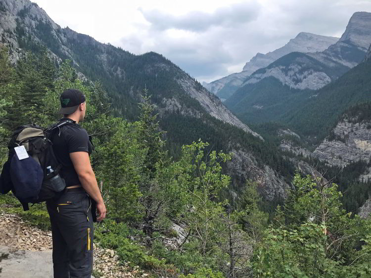 A picture of a young man taking in the view along the Heart Mountain hike near Canmore, Alberta. 
