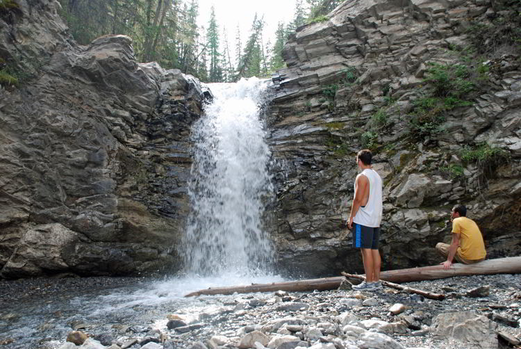 An image of two men near a waterfall on the Allstones Creek hike in Bighorn Backcountry, Alberta, Canada.