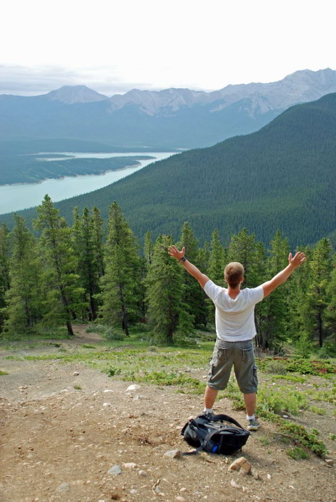 An image of a man with his arms up looking at the view along the Allstones Lake Trail in Bighorn Backcountry, Alberta, Canada.