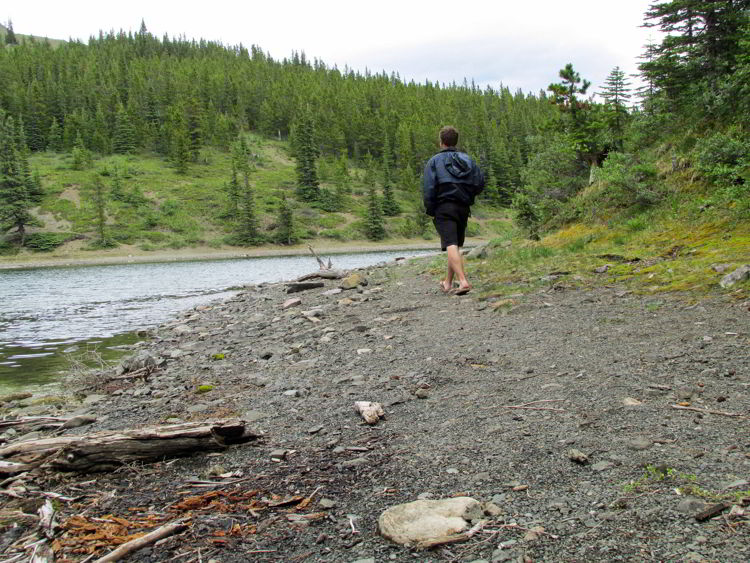 An image of a man walking around the shoreline of Allstones Lake in Alberta, Canada. 