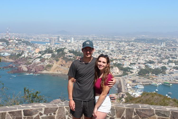 An image of a couple standing at the top of the El Faro Mazatlan hike in Mexico. 