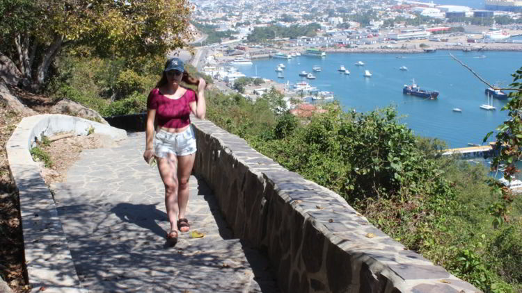 An image of a woman walking up the steps to El Faro in Mazatlan. 