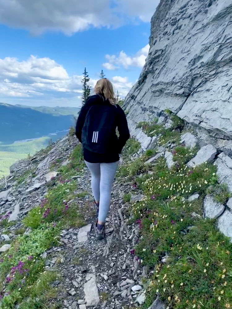 An image of a woman hiking up the trail to Nihahi Ridge in Kananaskis, Provincial Park in Alberta, Canada. 