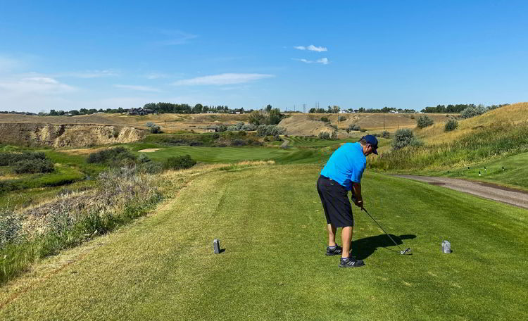 An image of a man teeing off at Desrt Blume Golf Course in Medicine Hat, Alberta, Canada - Things to do in Medicine Hat. 