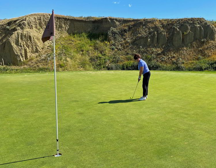 An image of a woman putting at Desert Blume Golf Course in Medicine Hat, Alberta, Canada. 
