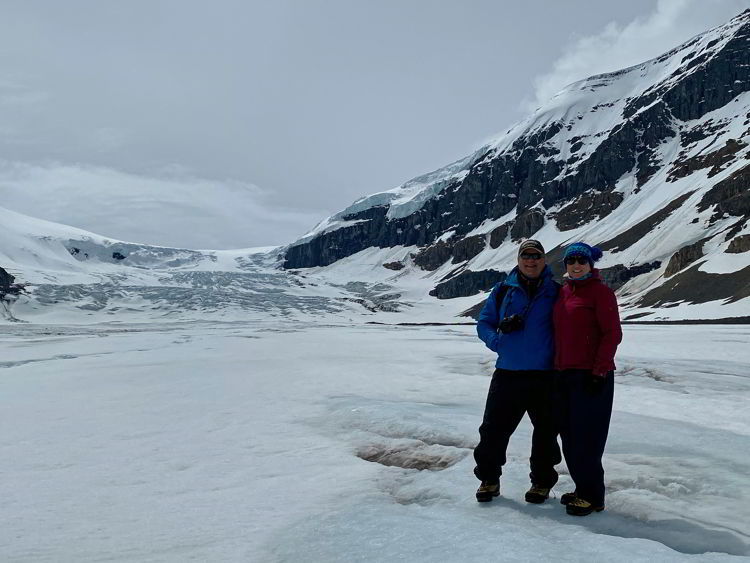 An image of a couple hiking on the Athabasca Glacier in Jasper National Park in Alberta, Canada. 