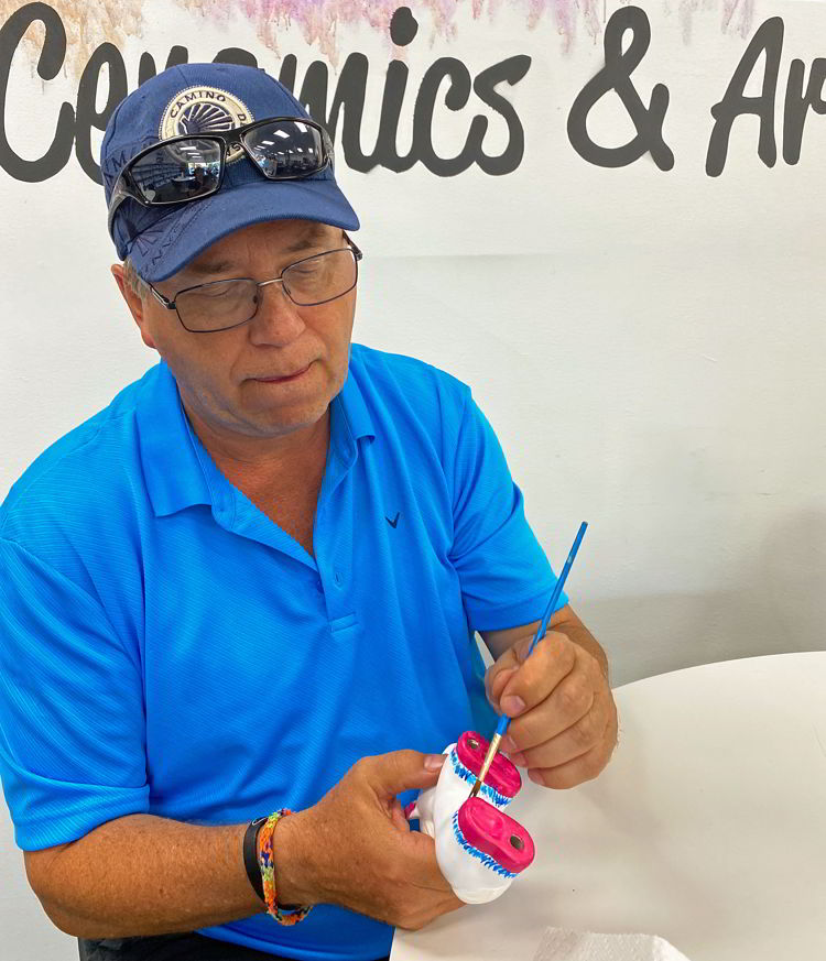 An image of a man painting a ceramic unicorn at Paint of Interest in Medicine Hat, Alberta, Canada. 