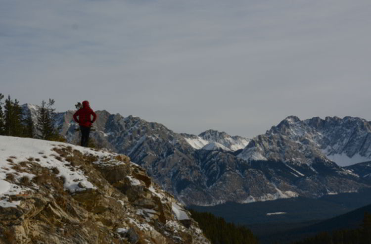 An image of a woman looking at the mountains in Kananaskis, Alberta Canada. 
