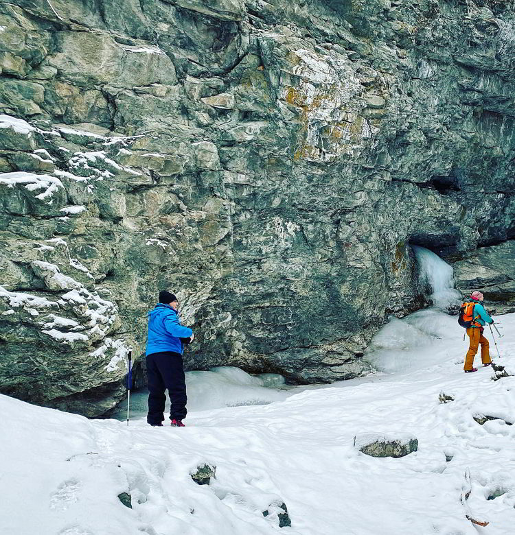 An image of two people hiking inside Star Creek Falls canyon in Crowsnest Pass, Alberta, Canada. 