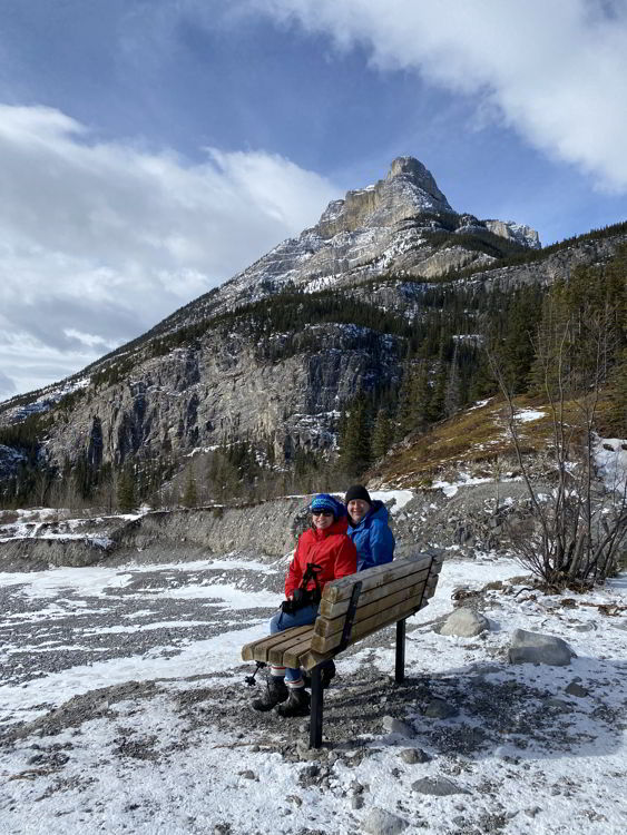 An image of a couple sitting on a bench on the Grotto Canyon hike - best easy hikes in Kananaskis. 