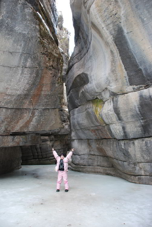 An image of a girl standing inside Maligne Canyon on a Jasper icewalk in Alberta, Canada. 