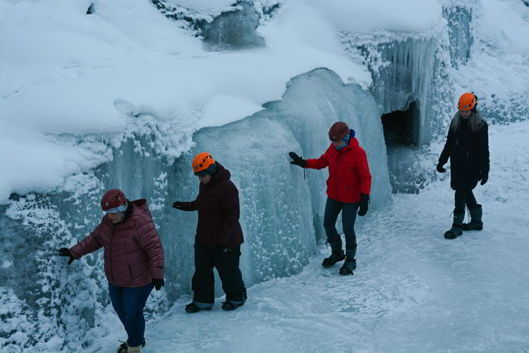 An image of a group of people walking along an ice formation in Maligne Canyon on a Jasper Icewalk. 