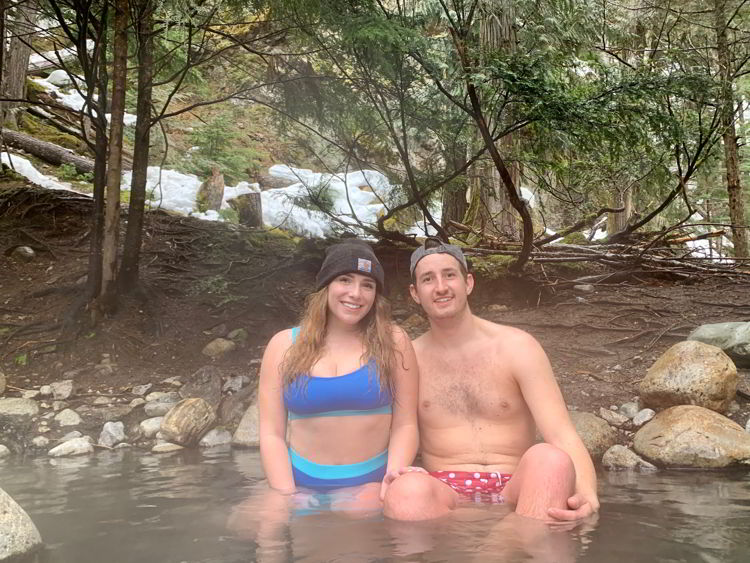 An image of a couple soaking in Halfway Hot Springs in British Columbia, Canada. 