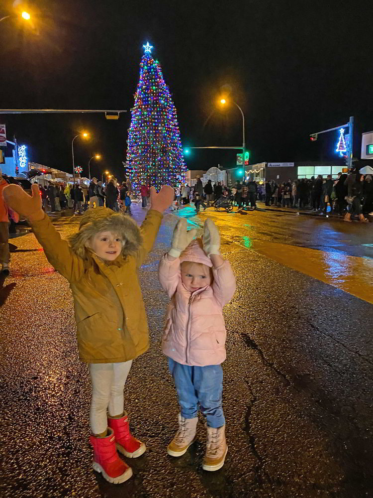 An image of two girls in front of the Stettler community Christmas tree in Stettler, Alberta, Canada. 