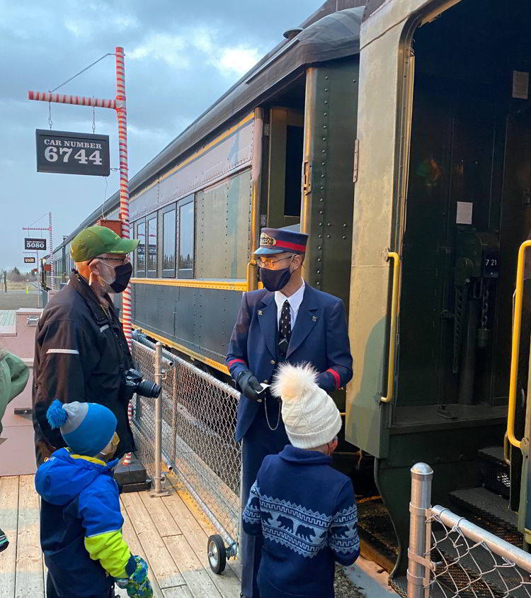 An image of people passing their tickets to the conductor t the Polar Express Stettler train in Stettler, Alberta, Canada. 