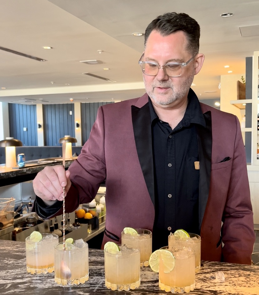 A picture of a man making cocktails.