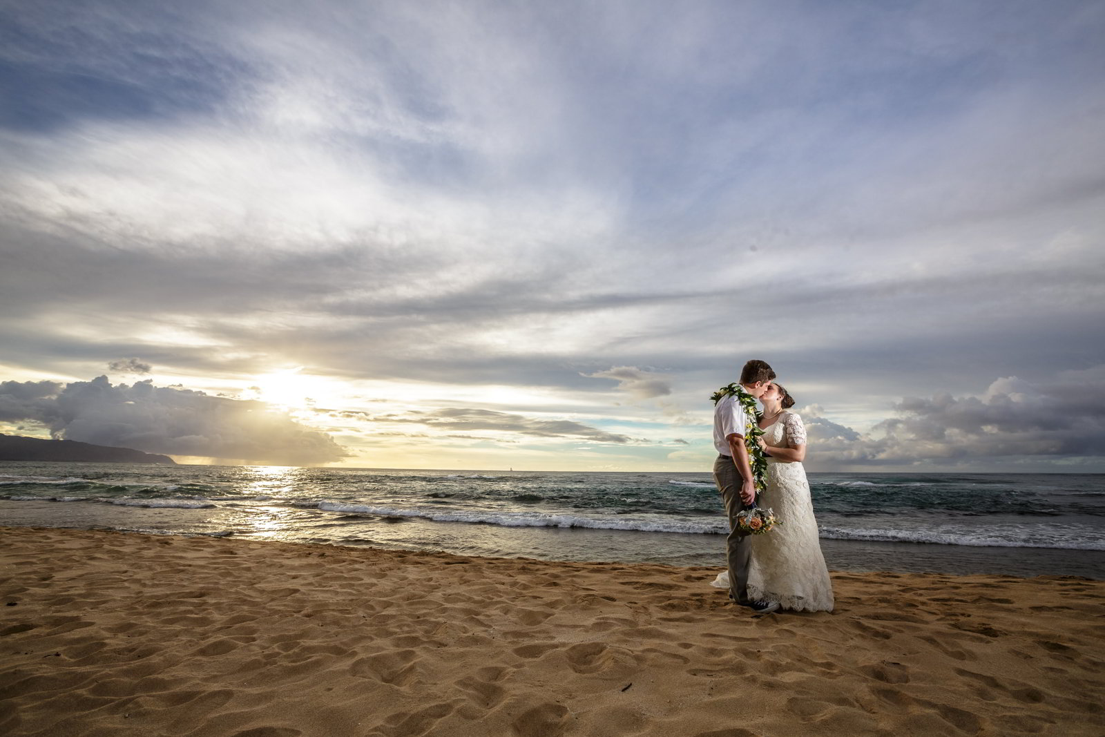 An image of a bride and groom on a beach in Hawaii