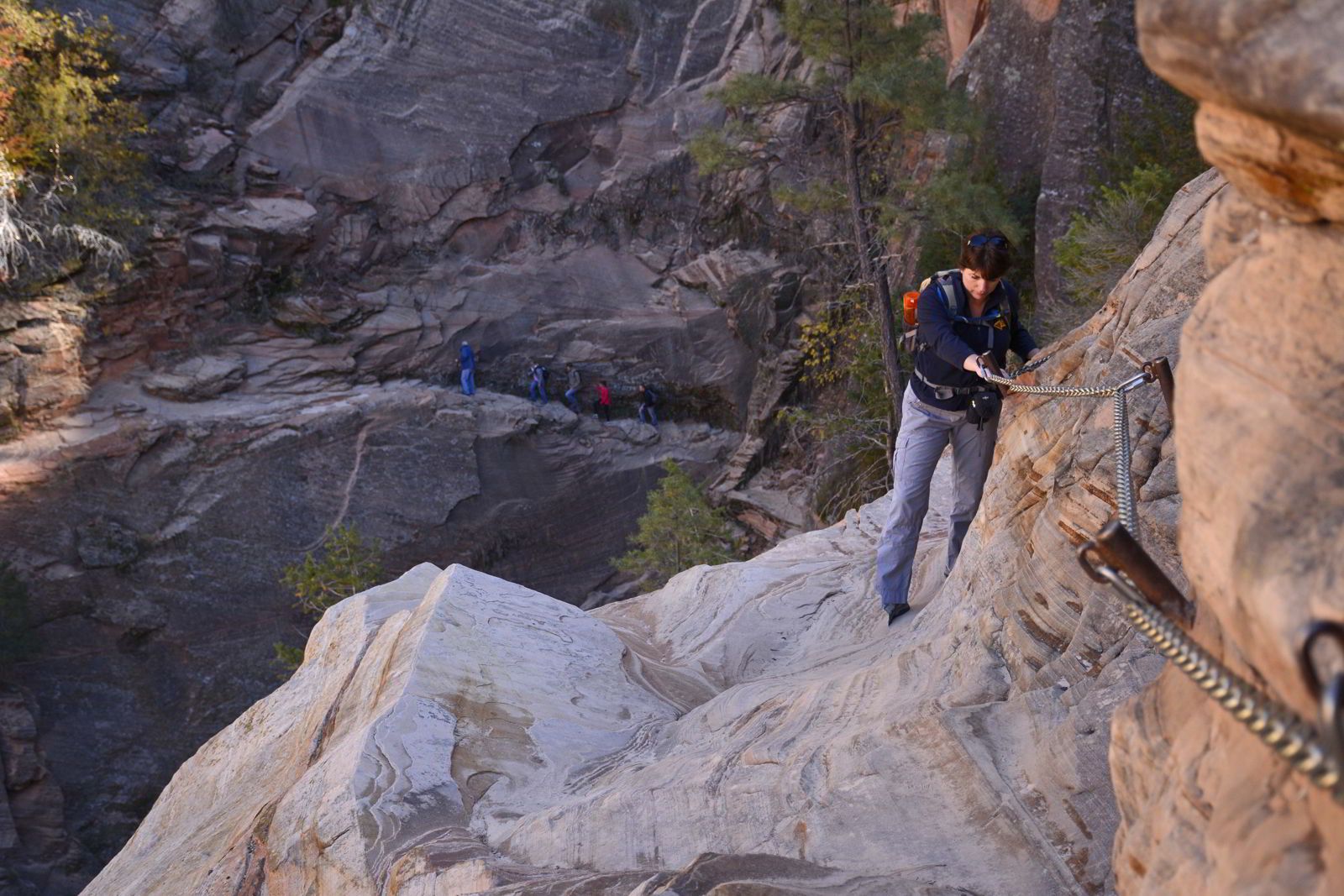 An image of the author grasping a chain to climb up Hidden Canyon Trail in Zion National Park in Utah - Best Zion National Park Hikes