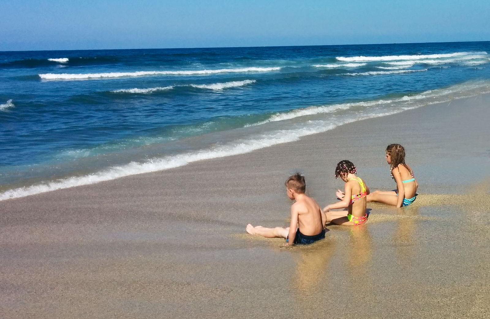 An image of three kids on a beach in Mexico.