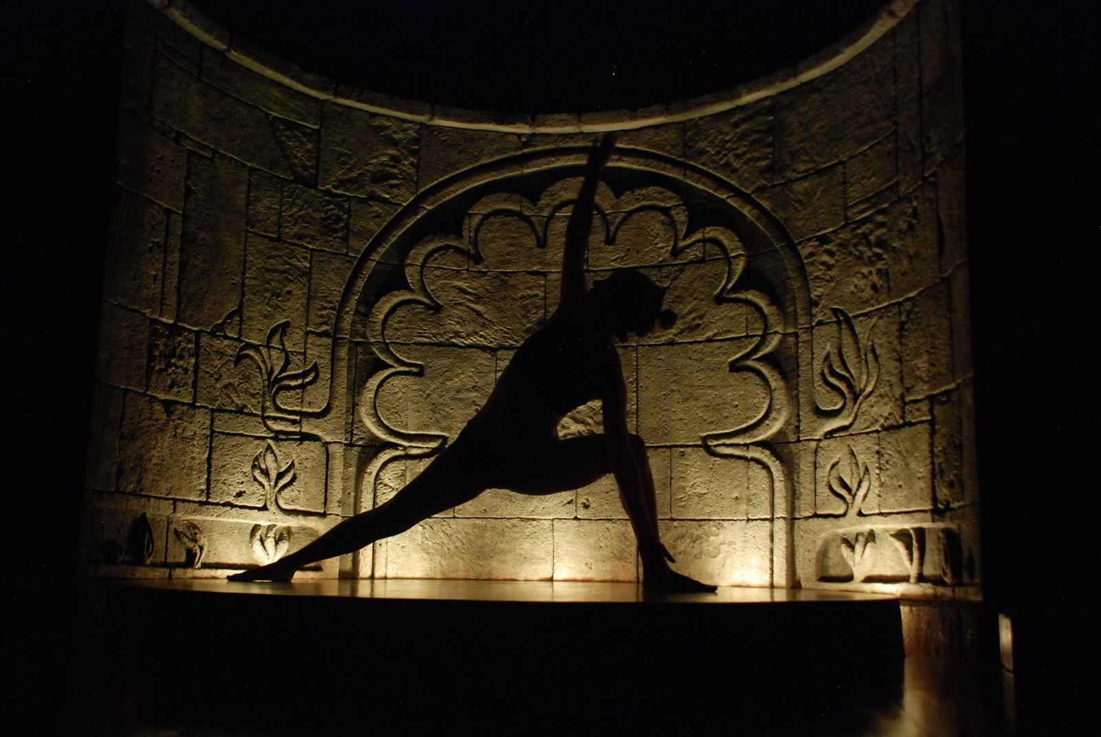 An image of a silhouette of woman doing a yoga pose.