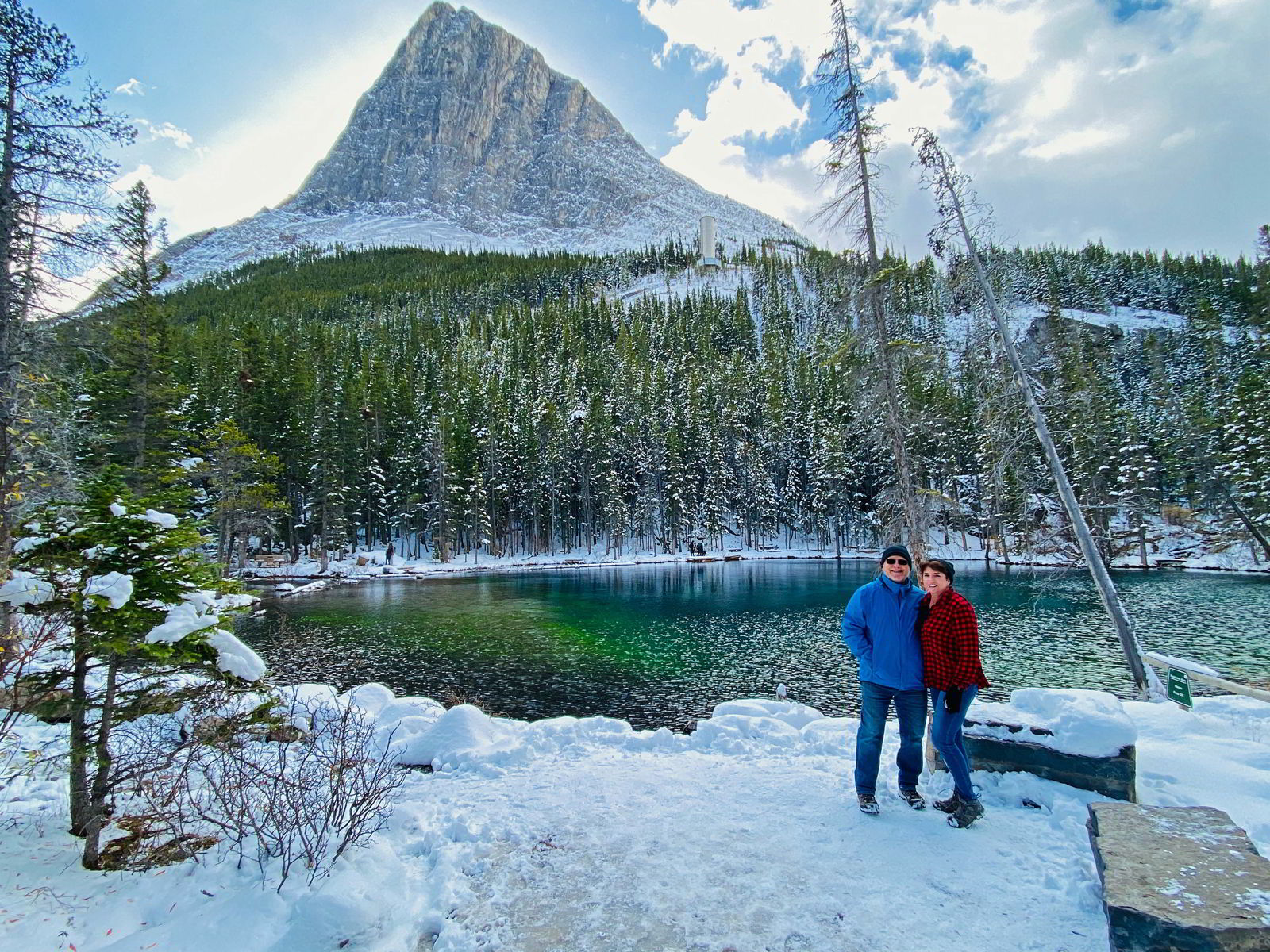An image of a couple standing in front of one of the Grassi Lakes - Canmore winter hikes and snowshoe trails