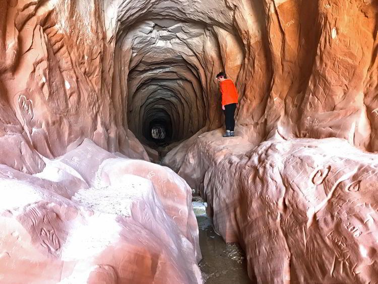 An image of a woman doing the Belly of the Dragon hike near Kanab, Utah. 