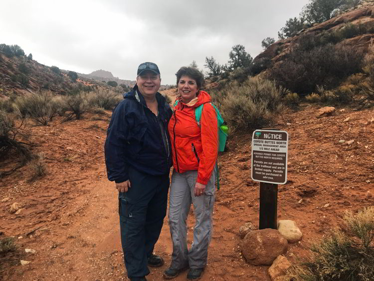 An image of a couple standing at the trailhead for Coyote Buttes North Wilderness Area in Utah, USA. 