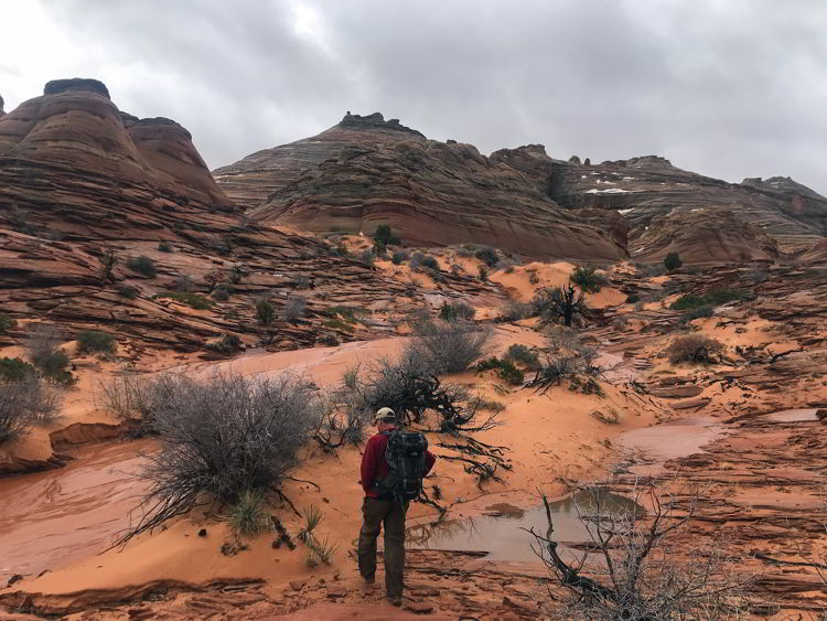 An image of a man hiking to The Wave in Arizona, USA. 