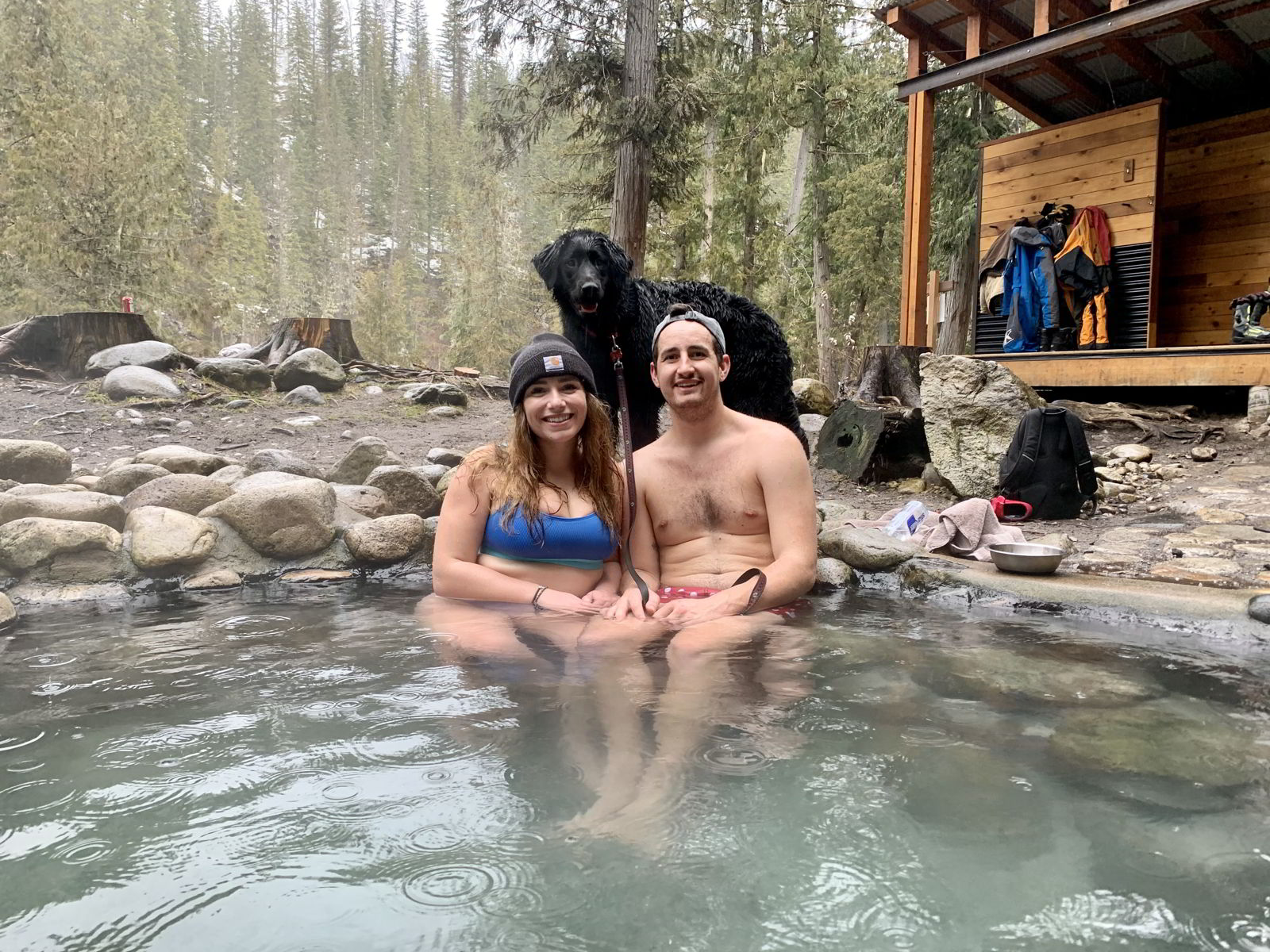An image of a couple and a dog at Halfway River Hot Springs in British Columbia, Canada.