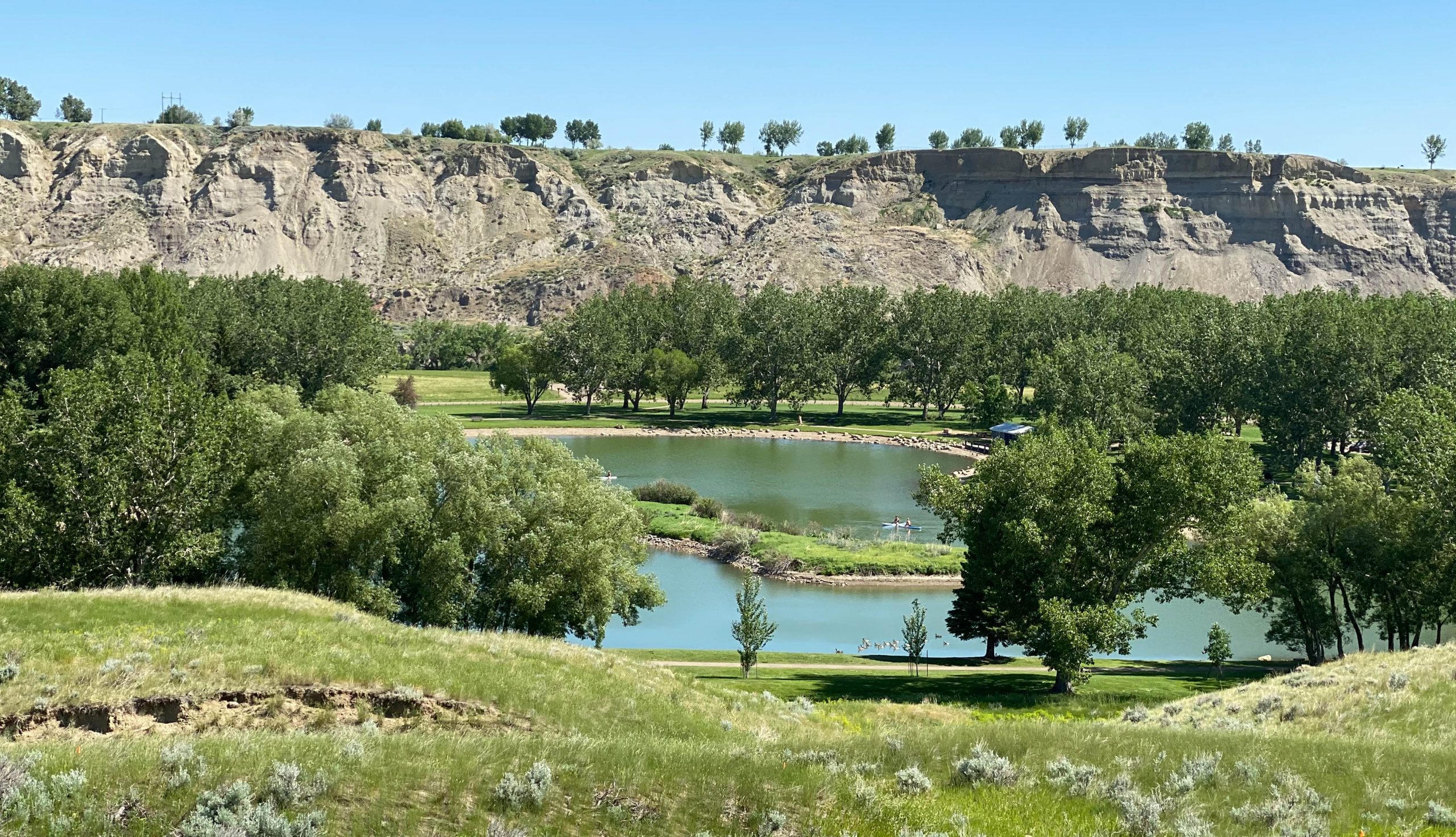 An image of Echo Dale Regional Park paddling Lake and cliffs in summer in Medicine Hat, Alberta, Canada.