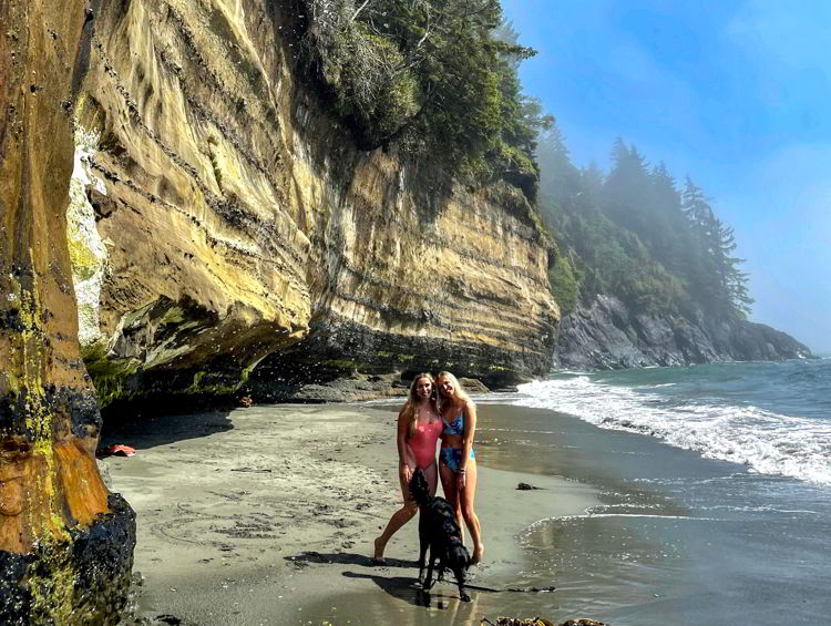 An image of two women standing on Mystic Beach, Vancouver Island in British Columbia, Canada.