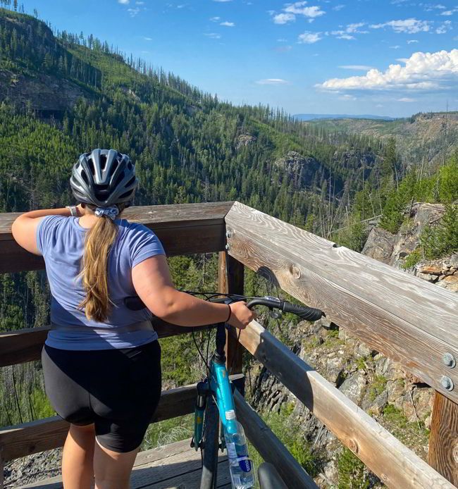 An image of a cyclist taking in the view in Myra Canyon near Kelowna, BC. 