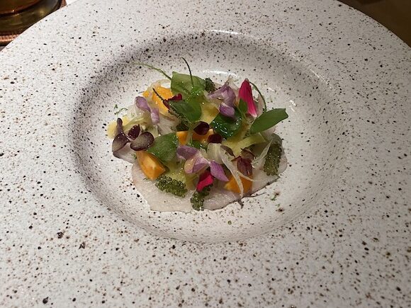 A dish containing giant trevally, sea grape, fennel, and pineapple at Jampa restaurant fine dining Phuket, Thailand.