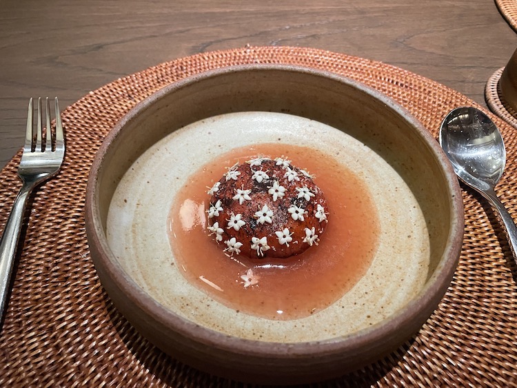 A dish containing watermelon, dhala flower, avocado, and dried fish at Jampa restaurant in Phuket.