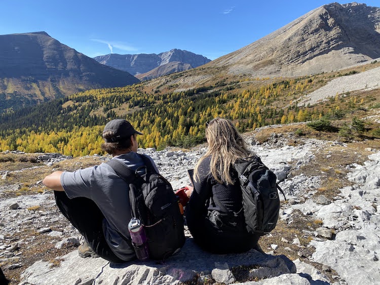 A couple eating lunch on a trail in Kananaskis.