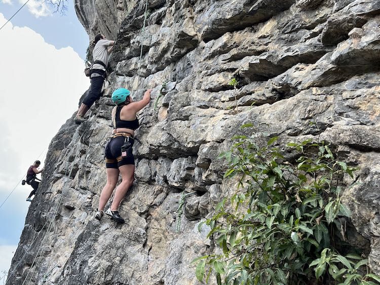 A woman rock climbing in Krabi, Thailand.