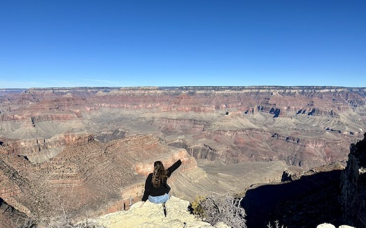 Girl sitting on the edge of the Grand Canyon