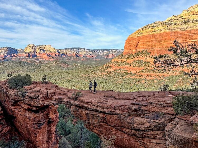 a couple walking on devil's bridge in sedona, arizona.