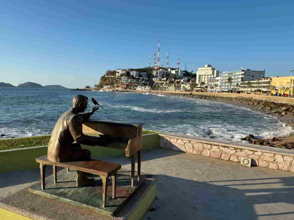 An image of a scupture of a man playing a piano on the Mazatlan Malecón. 